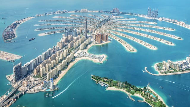 Aerial view of Dubai surrounded by Persian Gulf waters and with modern skyscrapers