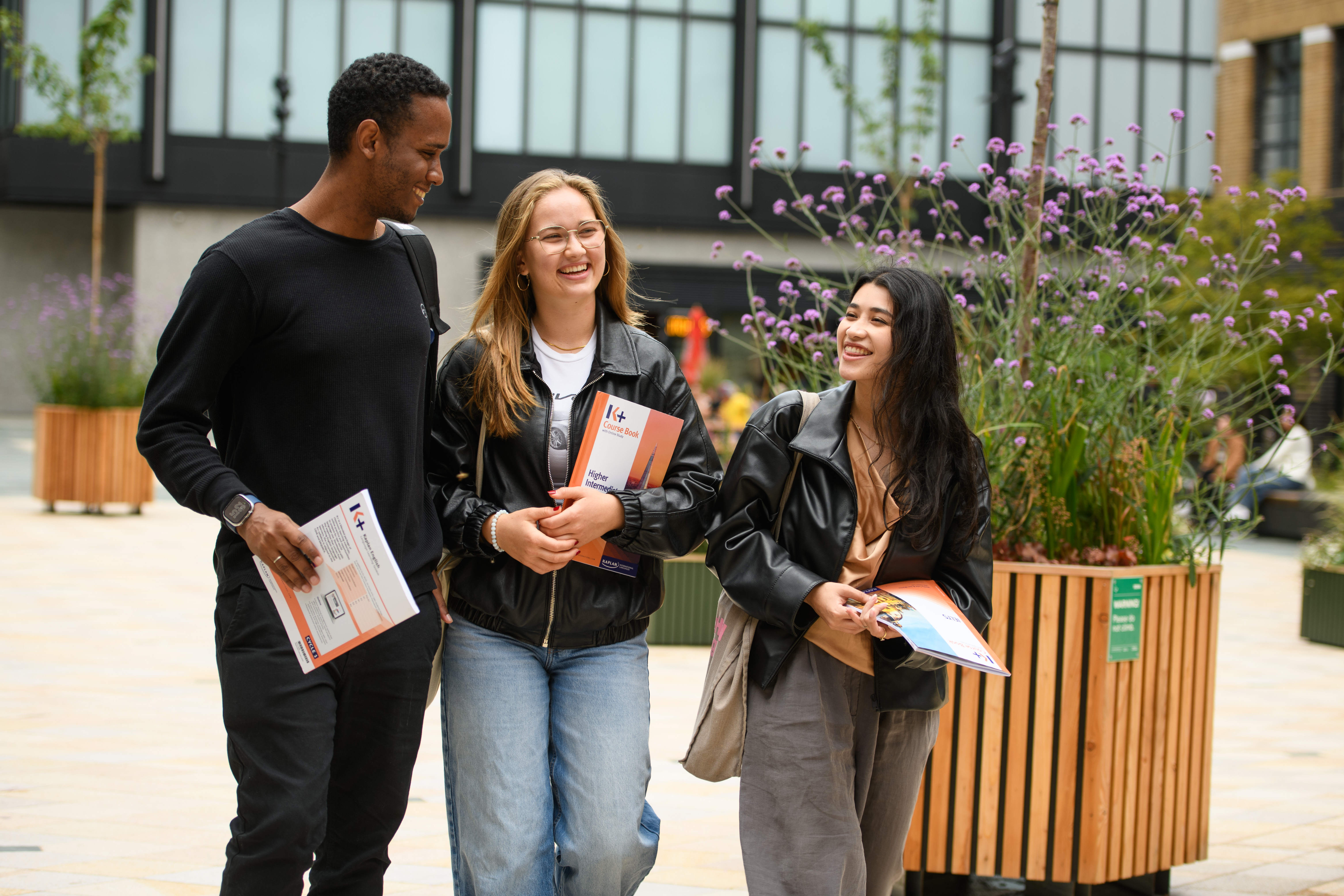 Group of Kaplan English School students holding folders outside the Manchester UK campus