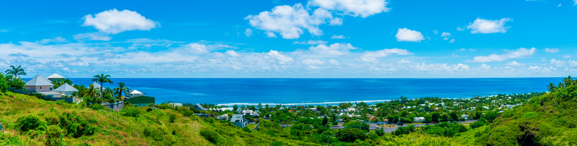 Coastline of Saint Gilles on Réunion Island, France, featuring sandy beaches, blue ocean, and tropical scenery