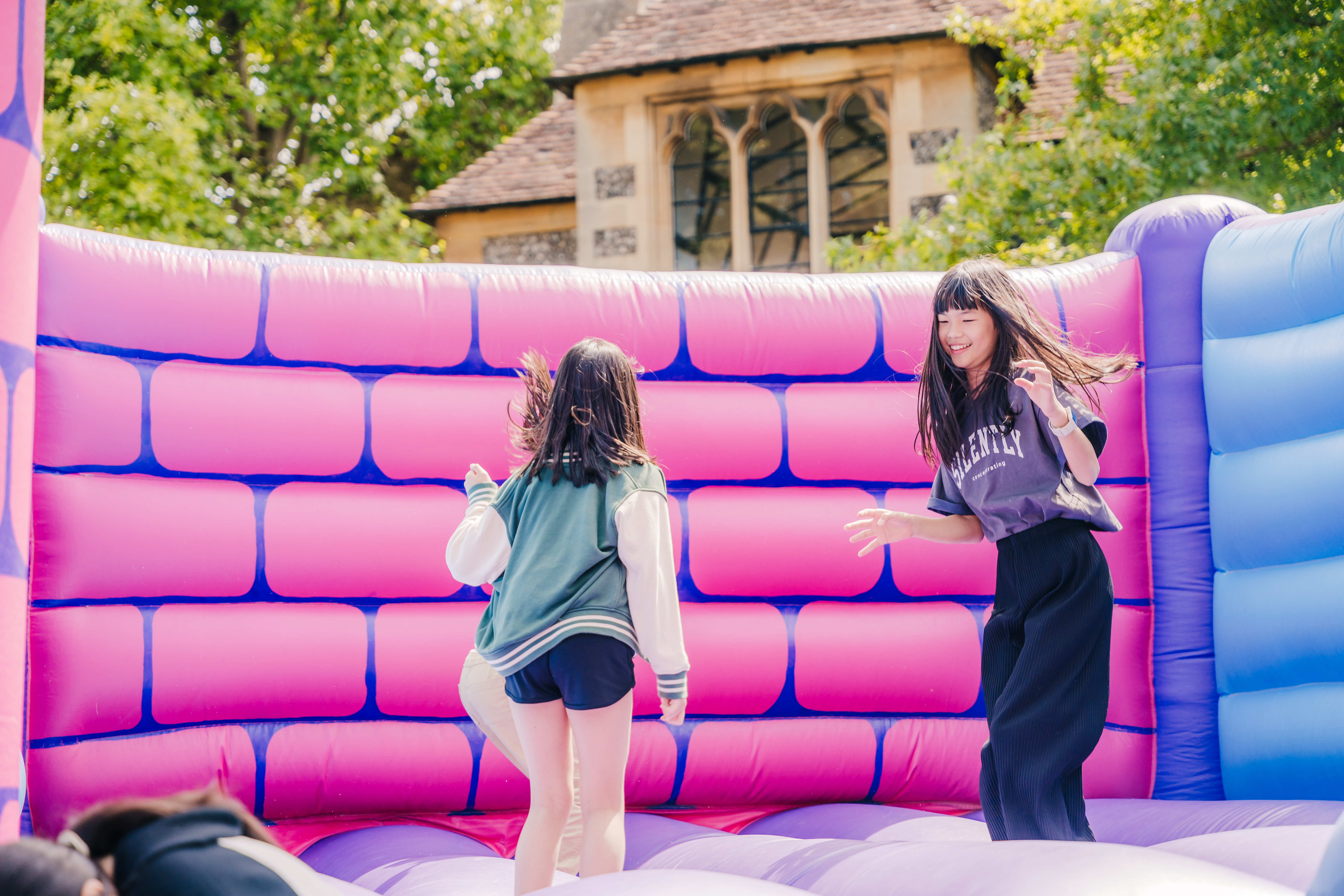 Two students jumping on an inflatable castle
