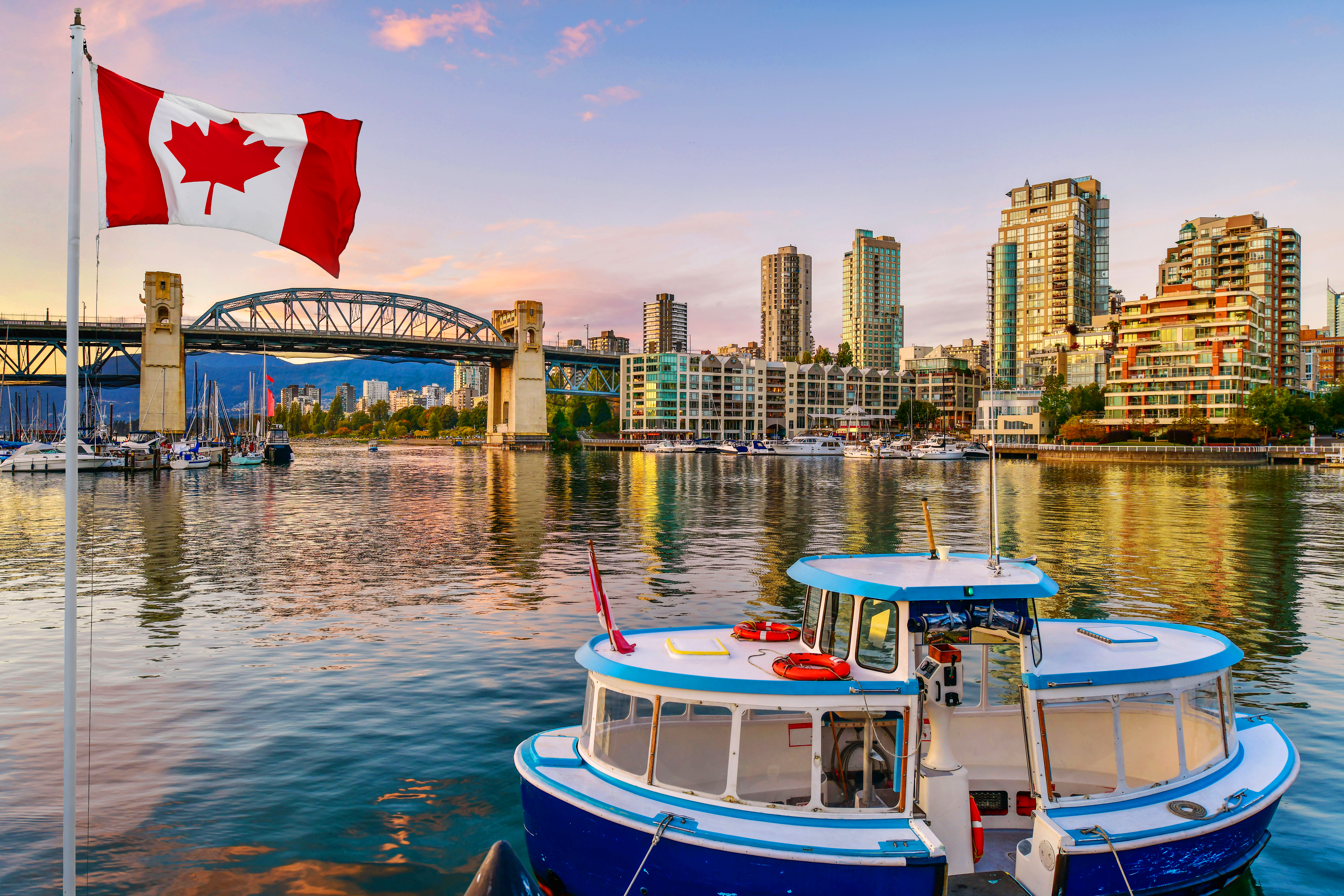 Ferry boat docked along in Granville island near Burrard Street Bridge at twilight in Vancouver, Canada