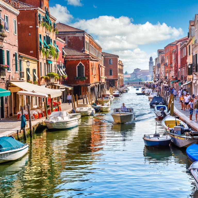Venice, Italy, featuring boats navigating narrow canals and charming historic streets