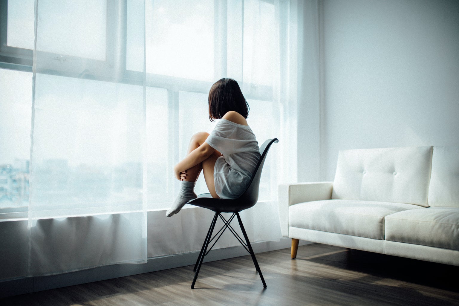 woman sitting alone looking out window