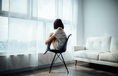woman sitting alone looking out window