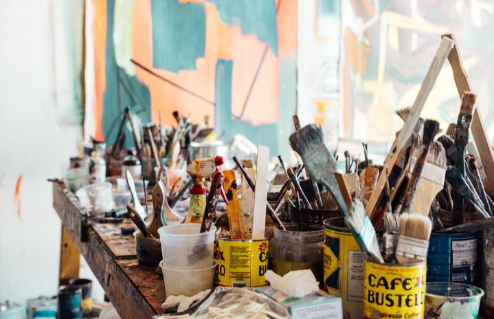 it is an image of paints and paint brushes on a table
