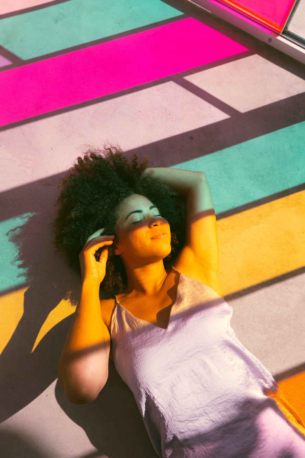Black woman on floor colored color glass light lighting sun shine shining rainbow shadows