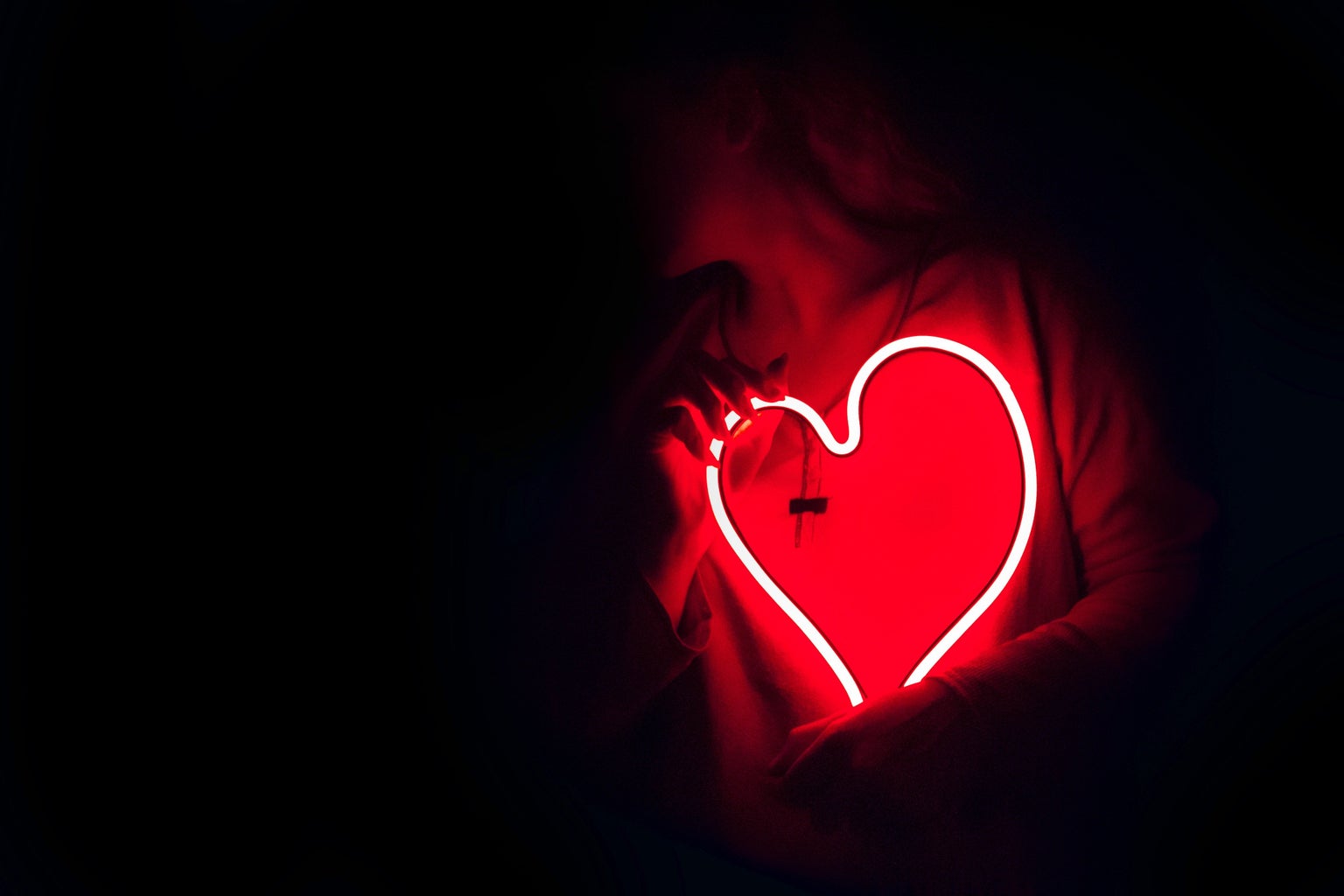 woman holding a neon red heart