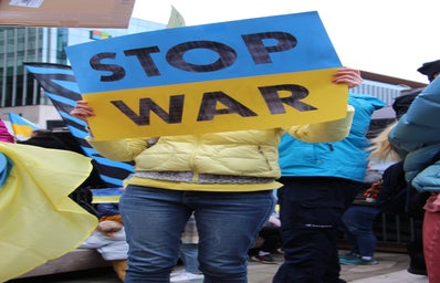 person holding a \'stop war\' Ukraine sign, protest
