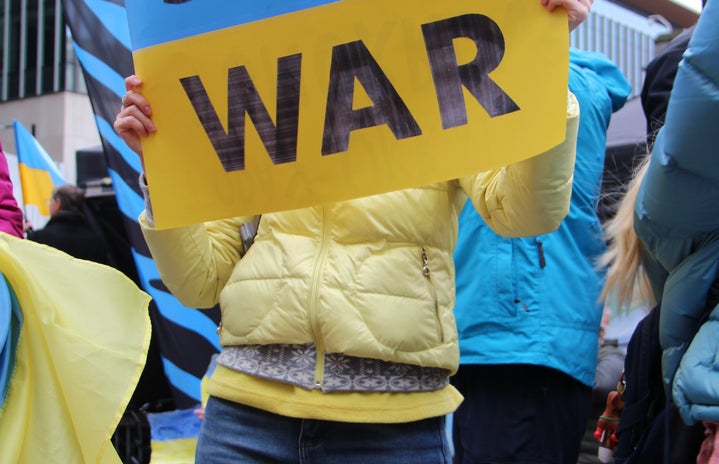 person holding a \'stop war\' Ukraine sign, protest