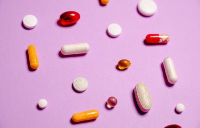 Vitamins laying on a pink background
