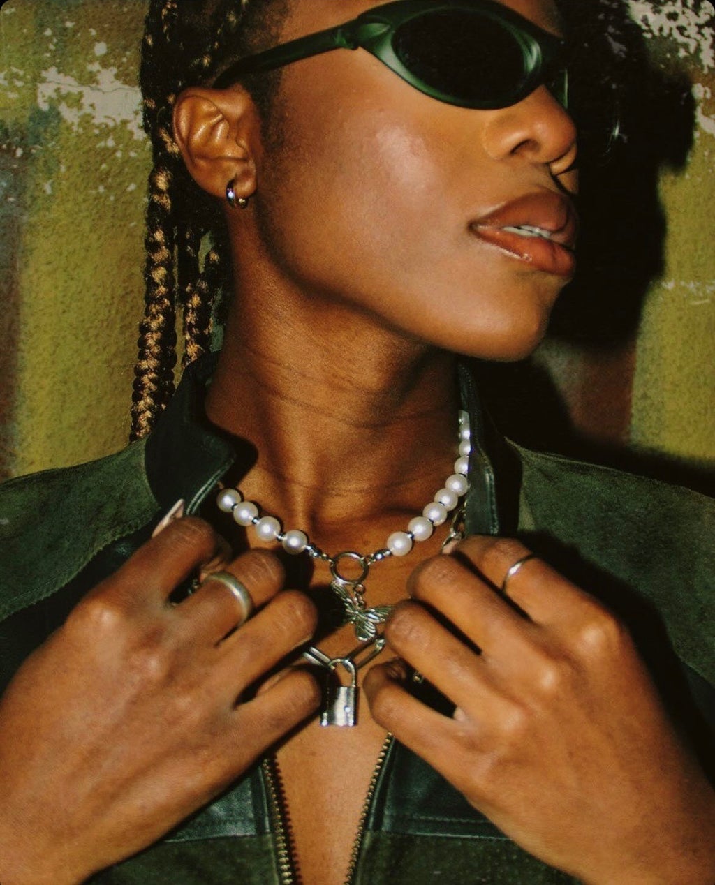 Close up shot of a model in sunglasse s showing off their jewelry.