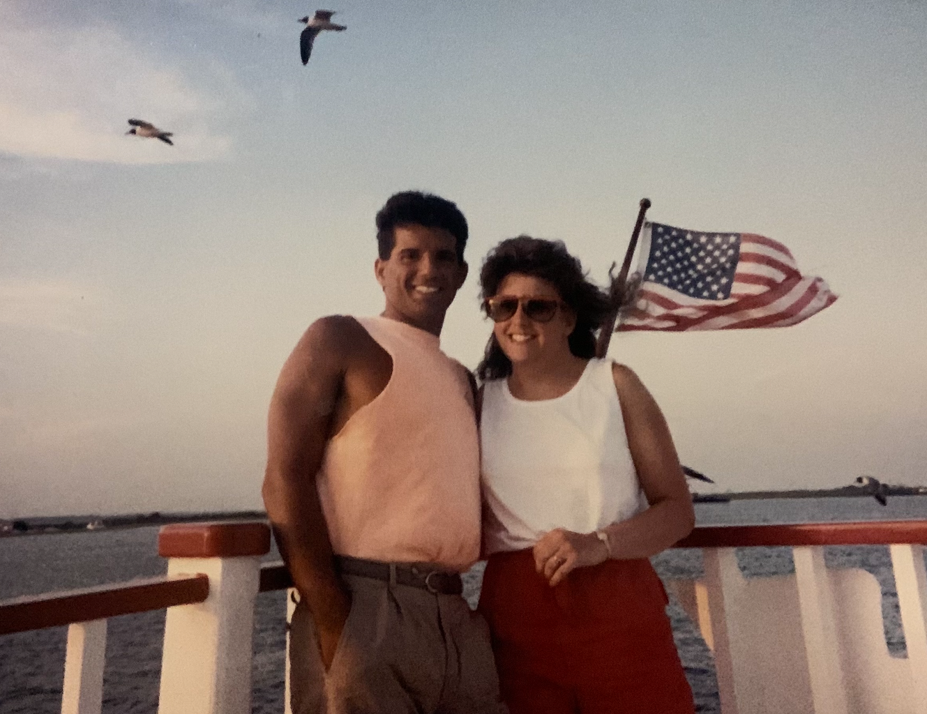 Couple posing with the American Flag in the background