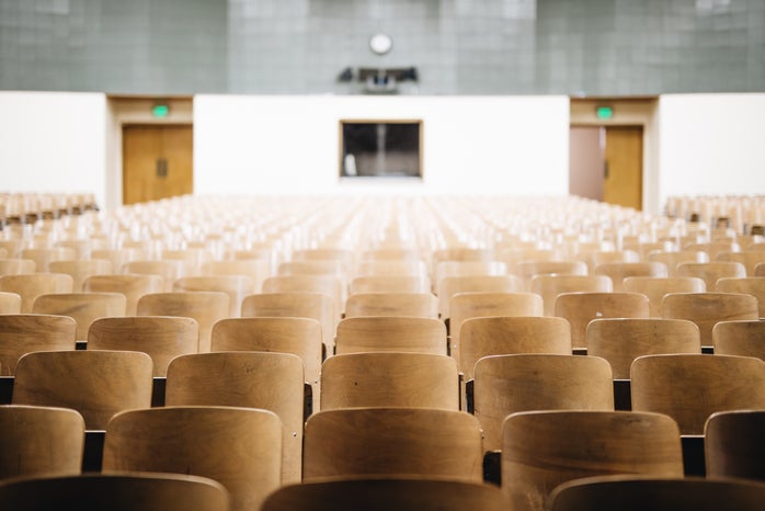 empty lecture hall with wooden chairs