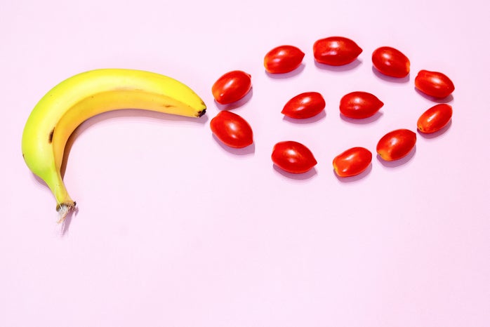 Banana and cherry tomatoes on pink background