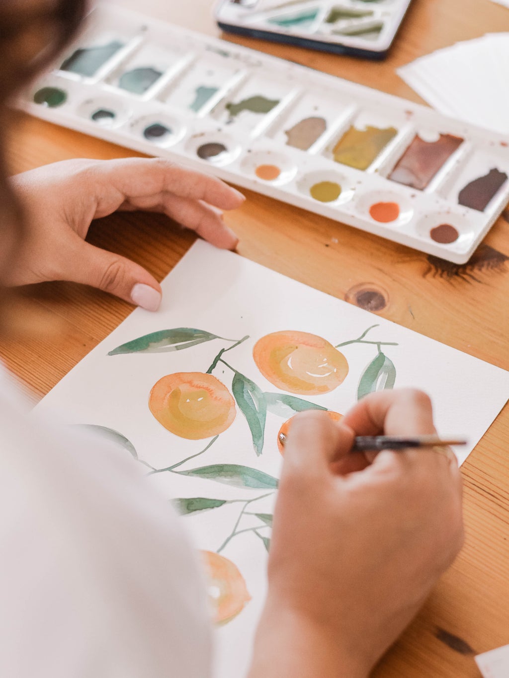 person painting orange fruit