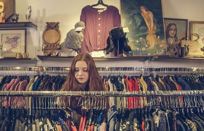 Woman looking through clothing rack in a thrift store