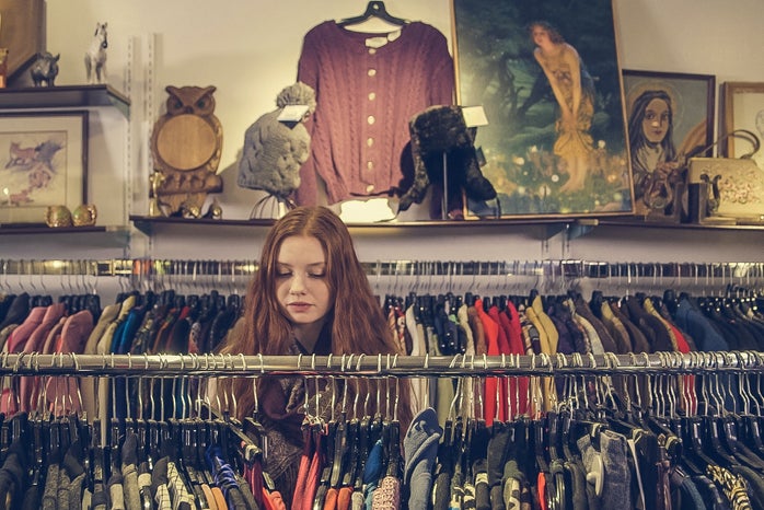 Woman looking through clothing rack in a thrift store