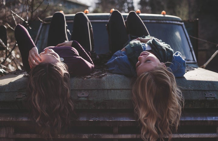 Girls lying on a car