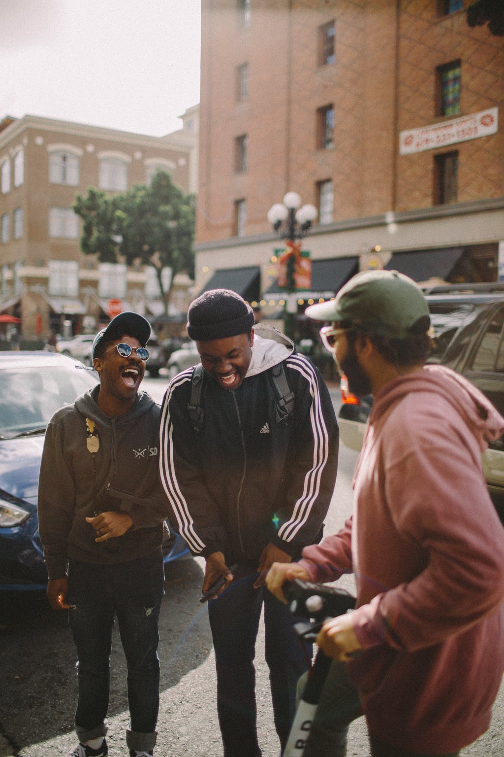 Three men in jackets laughing on the street