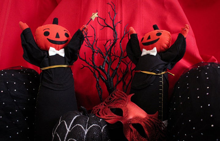 2 pumpkin figures in black with black accessories and red background