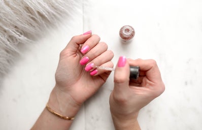 Girl painting her nails pink