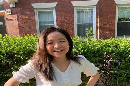 woman smiling in front of hedge