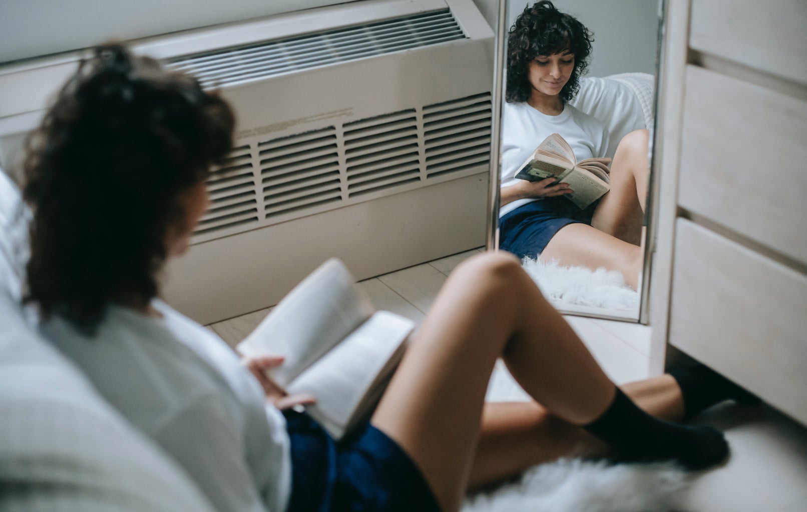 Woman with book resting in bedroom