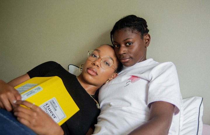 queer couple reading in bed