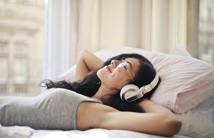 woman in gray tank top lying on bed