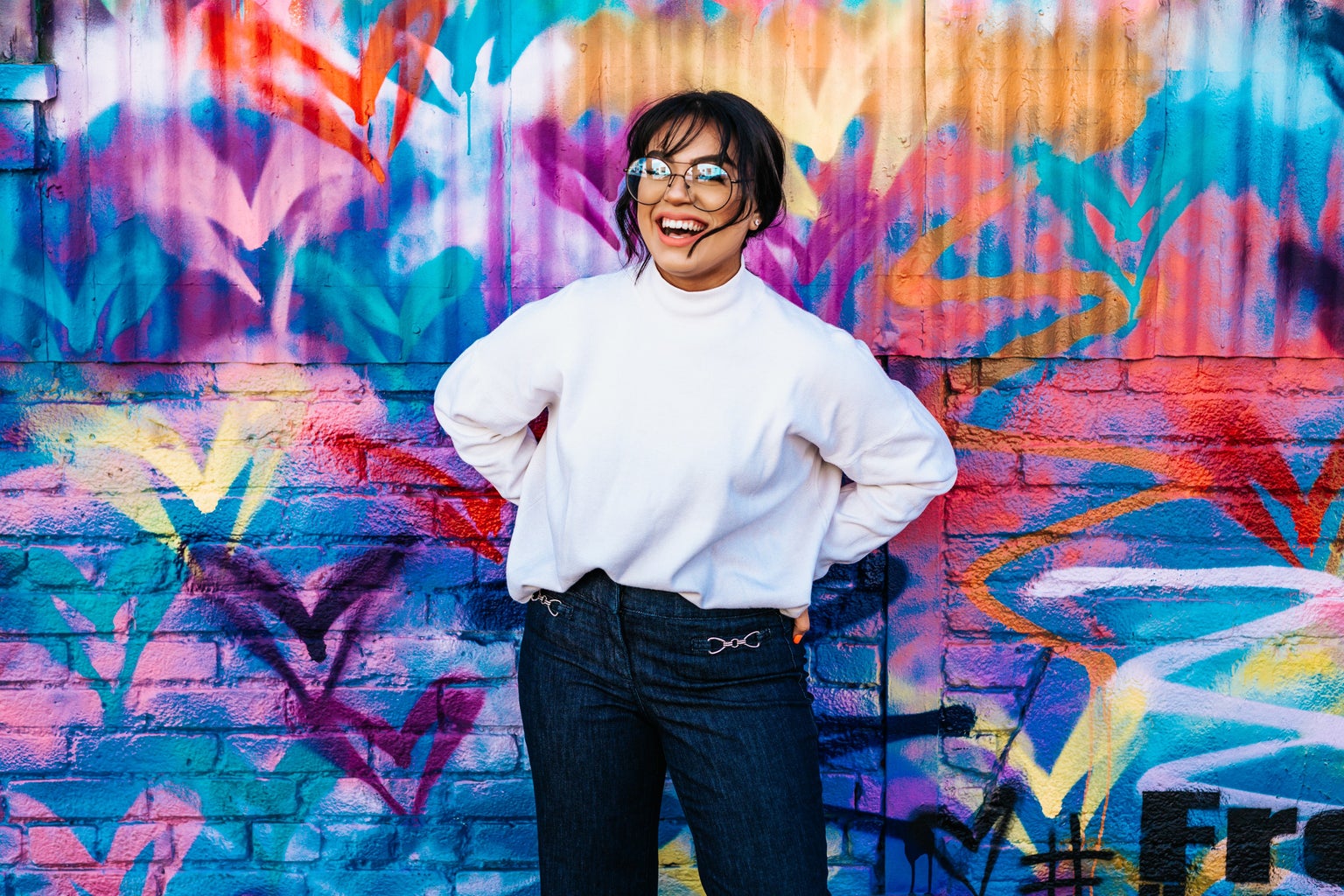 woman smiling in front of colorful wall