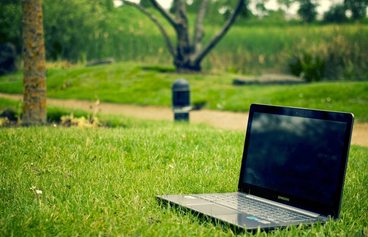 gray and black laptop sitting on the grass