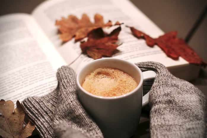 A coffee mug, leaves, and a book