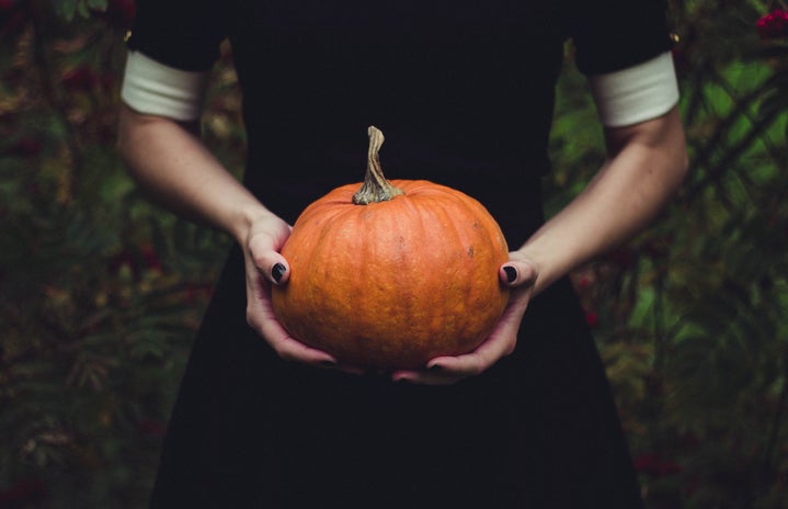 person holding a pumpkin