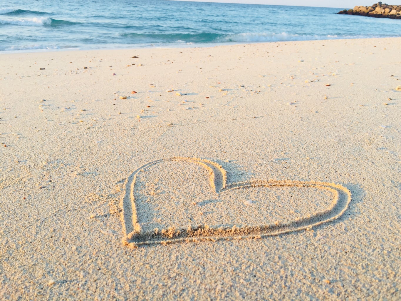 Heart drawn in the sand of the beach