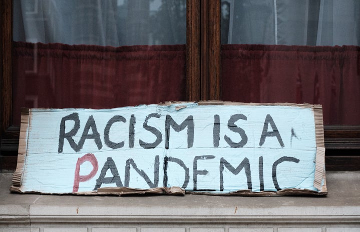 racism is a pandemic protest sign by Ehimetalor Akhere Unuabona?width=719&height=464&fit=crop&auto=webp