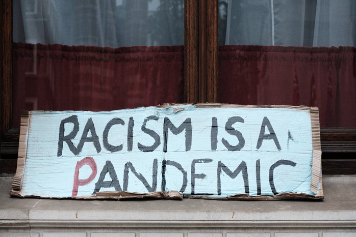 racism is a pandemic protest sign by Ehimetalor Akhere Unuabona?width=698&height=466&fit=crop&auto=webp