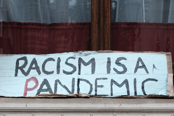 racism is a pandemic protest sign by Ehimetalor Akhere Unuabona?width=698&height=466&fit=crop&auto=webp