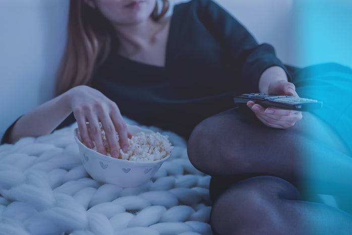 woman eating popcorn in bed by JESHOOTScom?width=698&height=466&fit=crop&auto=webp