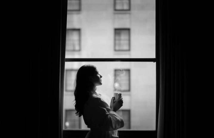Woman drinking coffee at window