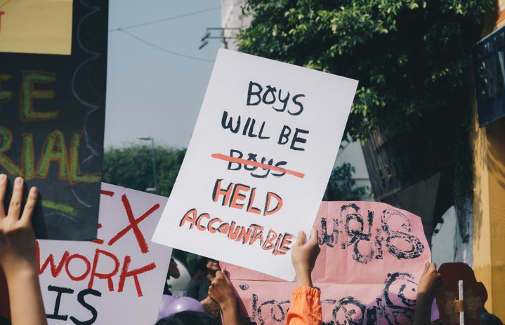 a sign at a protest with the phrase \"boys will be (boys) held accountable\"