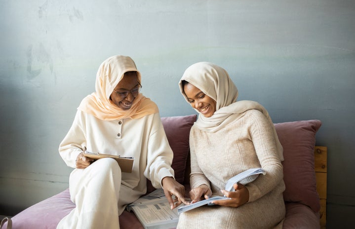 two women in hijabs reading