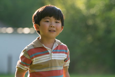David Yi (Alan S. Kim) looking somewhere and smiling.