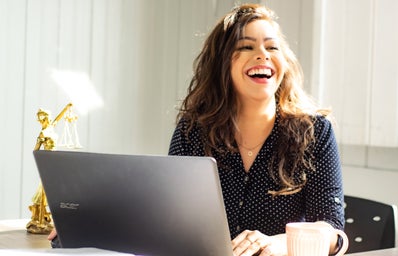 woman at laptop laughing