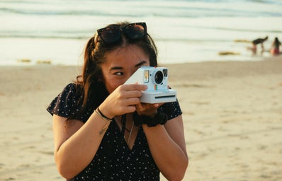 Woman taking a polaroid photo.