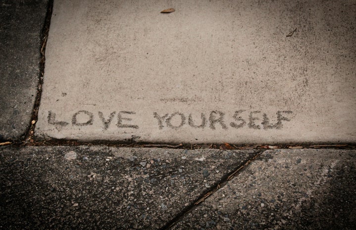 love yourself written on a sidewalk