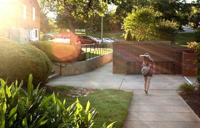 Student walking on a campus by her lonesome.