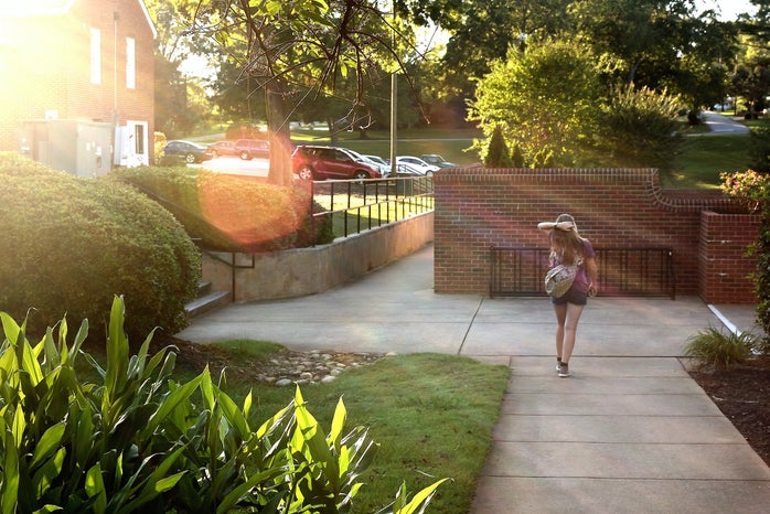 Student walking on a campus by her lonesome.