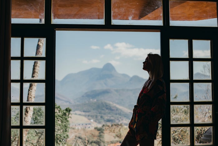 woman standing in doorway overlooking a mountain view