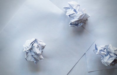 three crumpled balls of paper on top of paper sheets