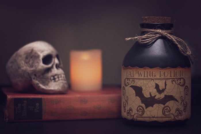 white skull on a book with a potion